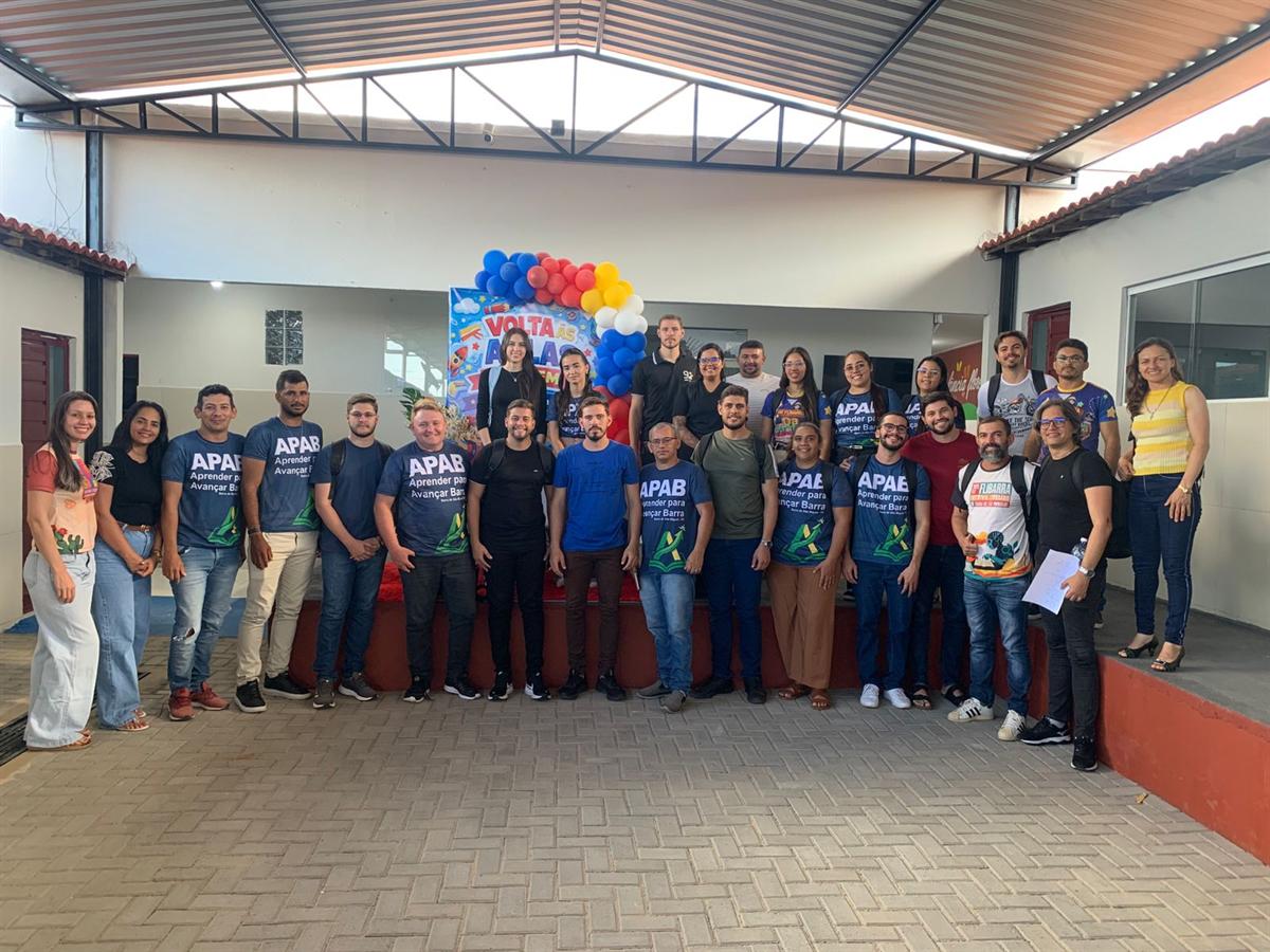 Professores de Barra de São Miguel reunidos para foto em um ginásio decorado com balões